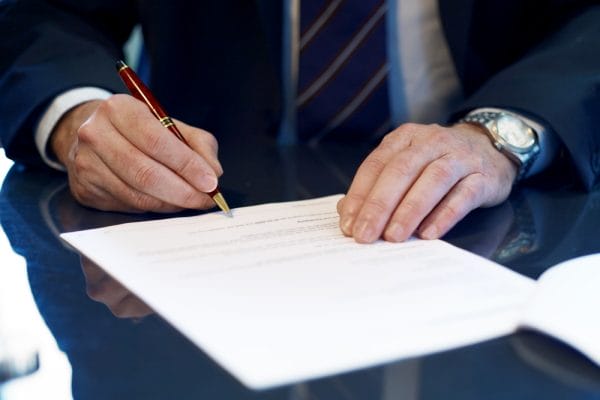 Close up of businessman signing a contract.