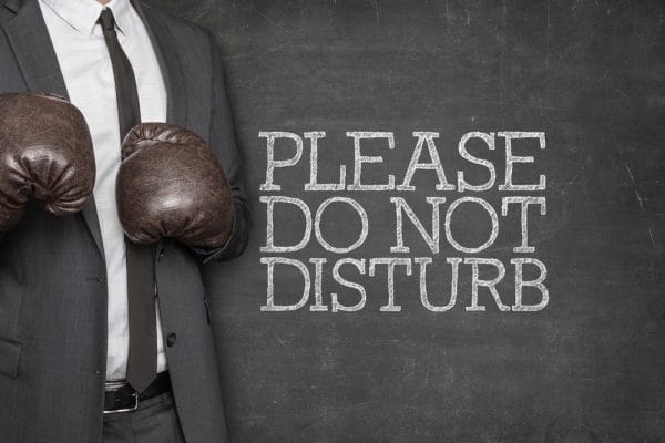 Please do not disturb on blackboard with businessman wearing boxing gloves