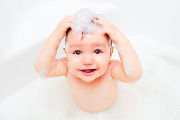 child washing in a bathroom in foam