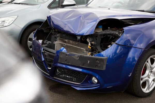 Detail Of Car Damaged In Motor Vehicle Accident Parked In Garage Repair Shop