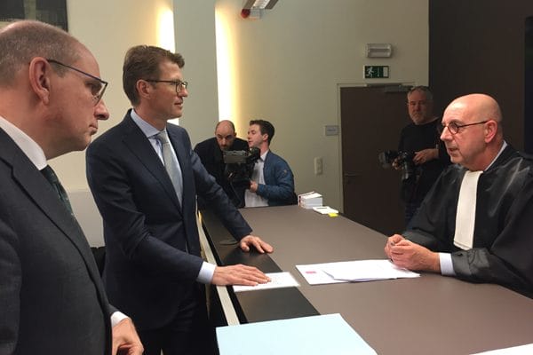 Minister Sander Dekker (m) praat na afloop van de zitting bij met vrederechter Jan Vandeborne (r). Links de Vlaamse minister Koen Geens (foto: Michel Knapen).