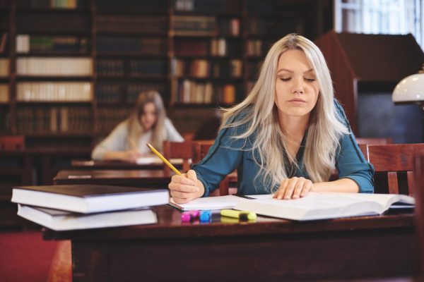 Woman working at desk taking notes